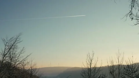 Winter Landscape Featuring a Distant Airplane Contrail Above Rolling Hills 库存影片 331167696