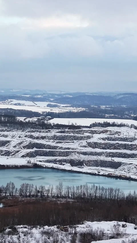 Winter landscape featuring a snow covered quarry and lake 動画素材 345205123