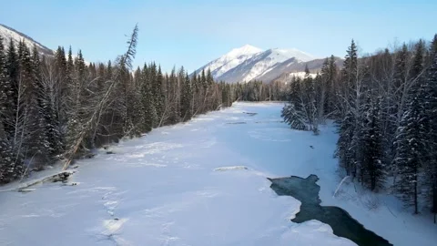 Winter landscape with a frozen river and snowcovered mountains Video stock 341908222