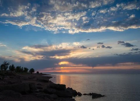 Winter landscape with lake and sunset fiery sky Stock Photos