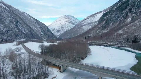Winter Landscape in More og Romsdal  Snowy Mountains, Frozen River, and Bridge Stock Footage 315472037