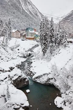 Winter landscape, mountain river flows between rocks in snow, coniferous forest Stock Photos