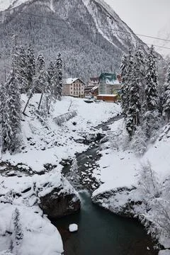 Winter landscape, mountain river flows between rocks in snow, coniferous forest Stock Photos
