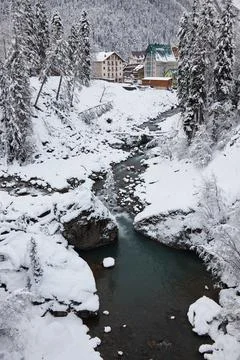 Winter landscape, mountain river flows between rocks in snow, coniferous forest Stock Photos
