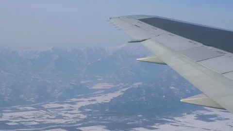 Winter landscape outside plane window. Wing in shot. 库存影片 90136268