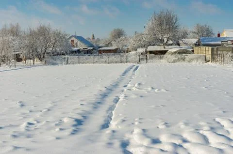 Winter landscape with pedestrian path through snow covered field Stock Photos