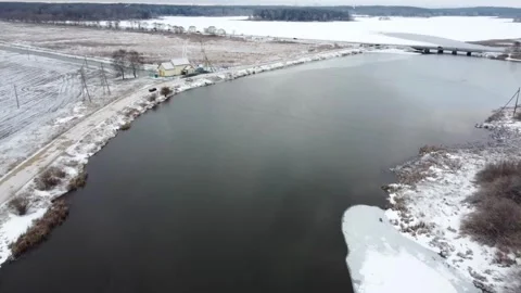 Winter landscape with river and snow-covered banks in a rural area during a clou Stock Footage 329433187
