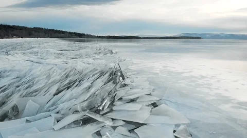 Winter landscape on the river bank. Sharp ice at the shore, sticking out of the Stock Footage 121497947