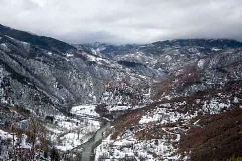 Winter landscape of river passing through mountains Stock Photos