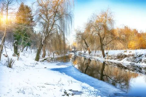 Winter landscape by a river in the sunset Stock Photos