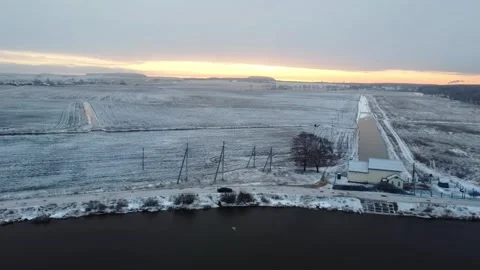 Winter landscape shows frozen fields and a river in the early morning light with Stock Footage 329825943