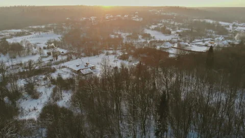 Winter landscape shows trees buildings in snowy area during sunset near cold Stock Footage 340408811