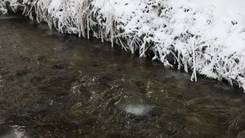Winter landscape with small stream and snow-covered banks, Mondseeland, Video stock 298085423