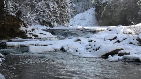 Winter landscape at a snow-covered river with gentle flowing water Stock Footage 289401054