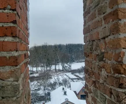 Winter landscape view through a brick wall opening- Stock Photos