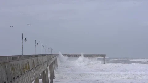  Winter, low tide, big waves smash into concrete seawall 스톡 동영상 112954260