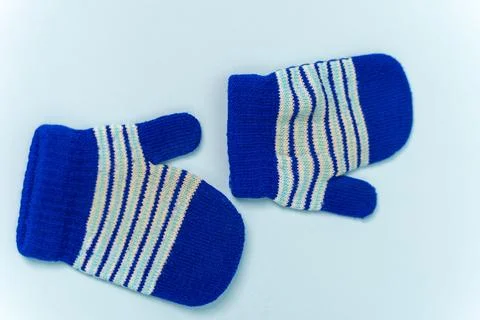 Winter mittens in blue with striped pattern on a white background Stock Photos