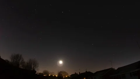 A winter moon passing through a starlight south east sky into a misty dawn Stock Footage 123317160