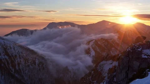 Winter mountain landscape, sunset in the background, clouds rolling in the Stock-Footage 228993983