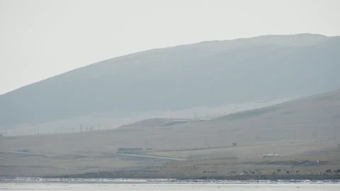 Winter Mountain Range Covered with Dry Grass Across Frozen Sea Stock Footage 326436236