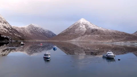 Winter mountain reflections on mirror flat icy water with boats. Drone, 4K Stock Footage 88876523
