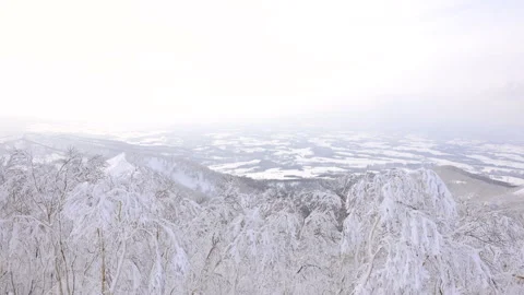 Winter mountain summit view of snow-covered town in Hokkaido Видео 328644828