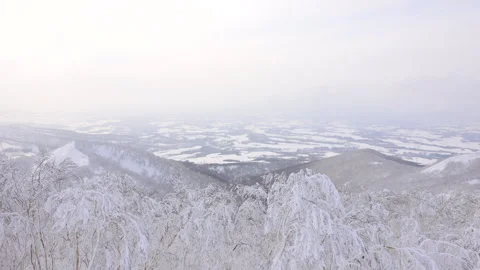 Winter mountain summit view of snow-covered town in Hokkaido Видео 328644830