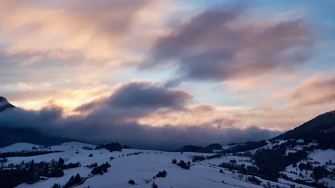 Winter mountain timelapse of clouds rolling over snowy peaks and forest during Stockbeeldmateriaal 336394249