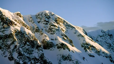 Winter mountains covered in snow with clear blue sky during sunrise Stock Footage 121578352