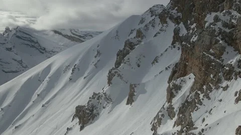 Winter mountains covered by snow - Drone shot next to the rocky walls Video stock 230166022