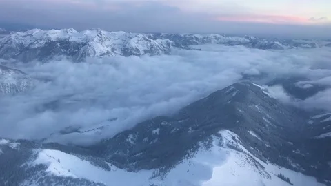 Winter mountains with snow and clouds filmed from airplane landing at Innsbruck  Stock Footage 85434144