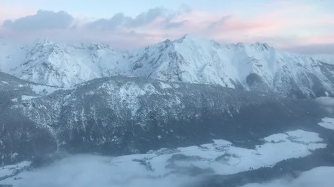 Winter mountains with snow and clouds filmed from airplane landing at Innsbruck  Stock Footage 85435005