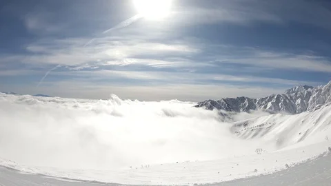 Winter mountains with snow, clouds and sunshine. Hakuba filmed from top lift Stock Footage 86560675