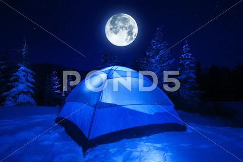 Winter Night Camping In Heavy Mountains Snow. Large Full Moon On The Night Sk