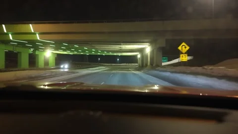 Winter night city traffic from car driving through snowy street Stock Footage 329536645