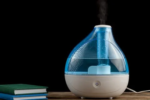Winter night, cold, flu concepts with an ultrasonic air humidifier creating c Stock Photos
