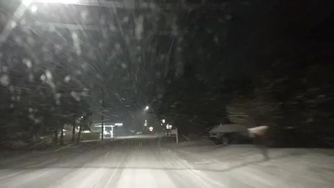 Winter Night Drive Through Snow-Covered Streets in a Suburban Neighborhood Stock Footage 258123106