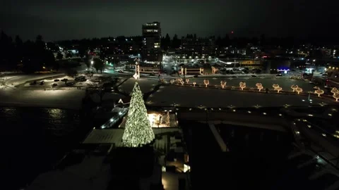 Winter night drone shot of a small town with Christmas lights and snow Stock Footage 224373489