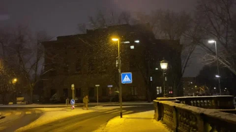 Winter night scenery with falling snow in Braunschweig city at old stone bridge  Stock Footage 297411316