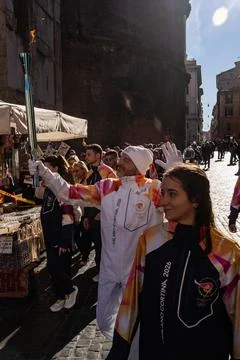 Winter Olympic torch relay runner carrying torch in crowd Stock Photos