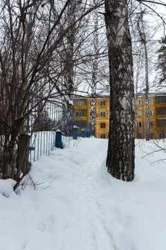 Winter path in an old courtyard with a panel house Stock Photos