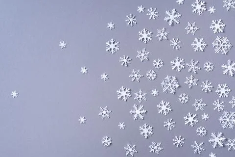 Winter pattern made of white snowflakes on grey background. Top view. Flat lay Stock Photos