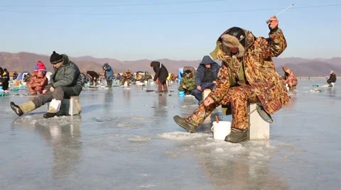 In winter, people catch fish from under the ice in the river. Russia. Stock Footage 58412755