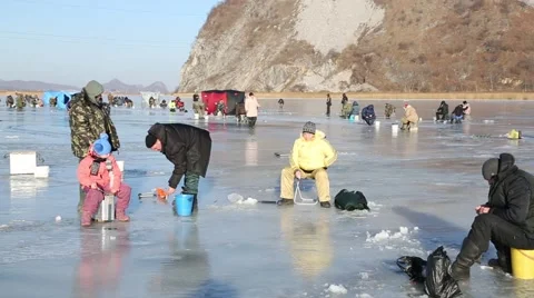In winter, people catch fish from under the ice in the river. Russia. Video stock 58412824