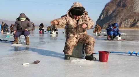 In winter, people catch fish from under the ice in the river. Russia. Stock Footage 58412828