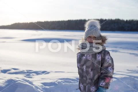 Winter portrait of happy little girl wearing knitted hat and scarf. Stock Photos