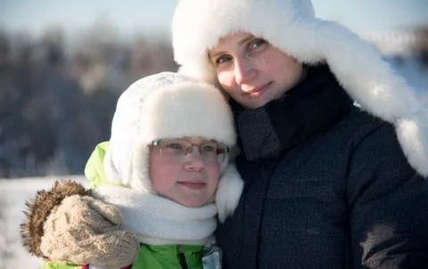 Winter portrait of mother and daughter in white hats Stock Photos
