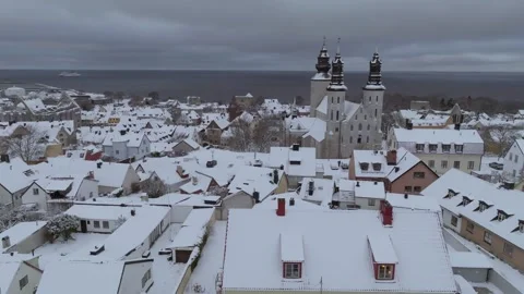 Winter Pullback from Visby Old Town to Snowy City Wall in Östergravar Stock Footage 330034531