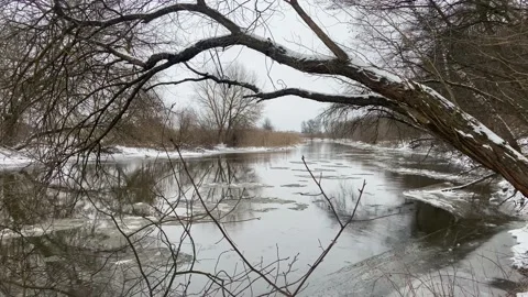 A winter river, the current carries ice. Chunks of ice and snow in the river Stock Footage 230031678