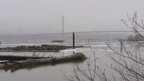 Winter on a river. Floating ice. Logs. A foggy bridge on a distance. Vidéo 148514045